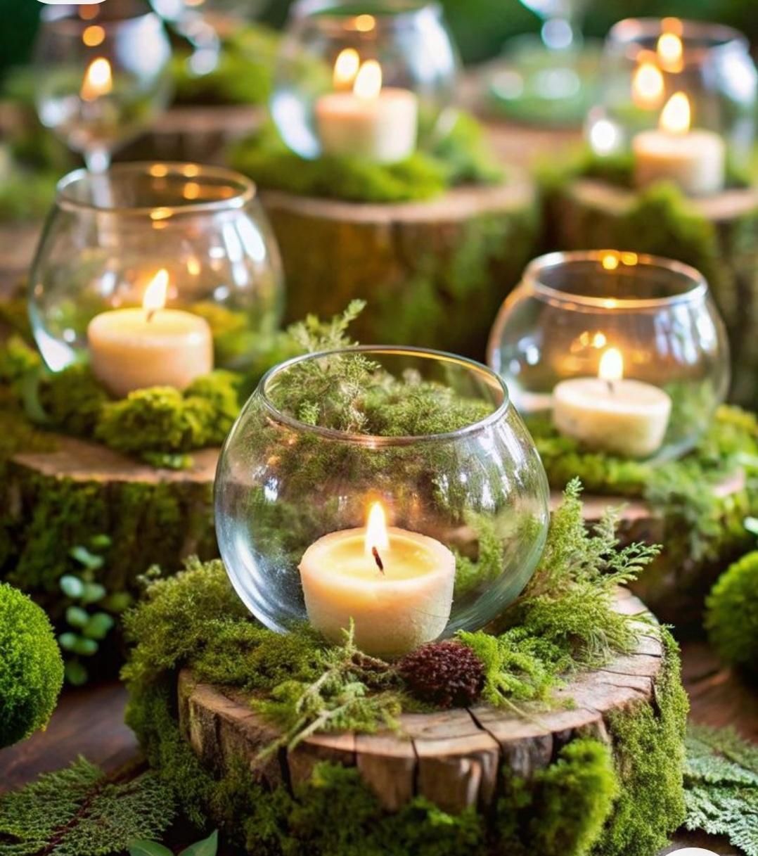 Glass bowls with candles on mossy wooden stumps.