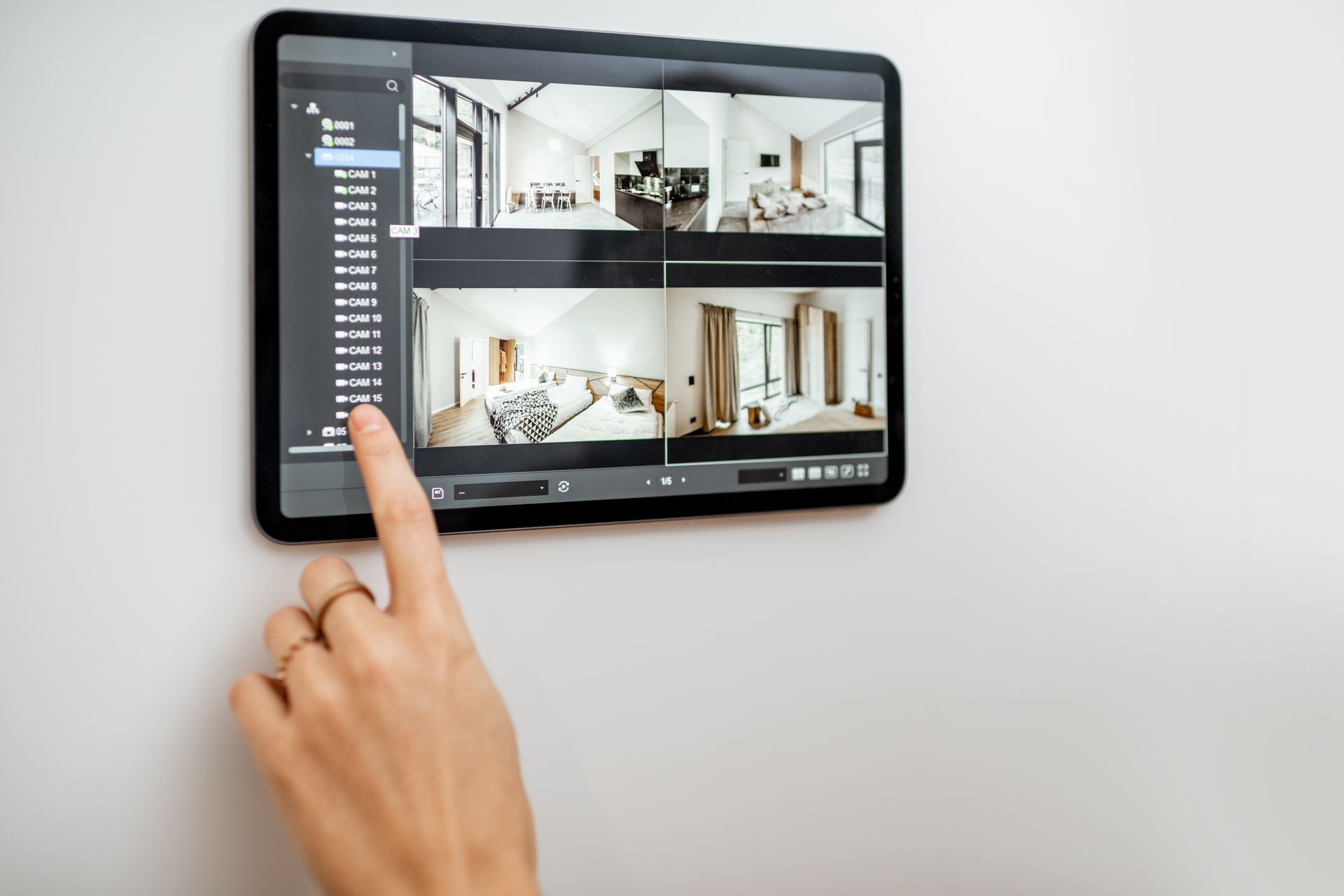 A woman is checking the security camera on a tablet.