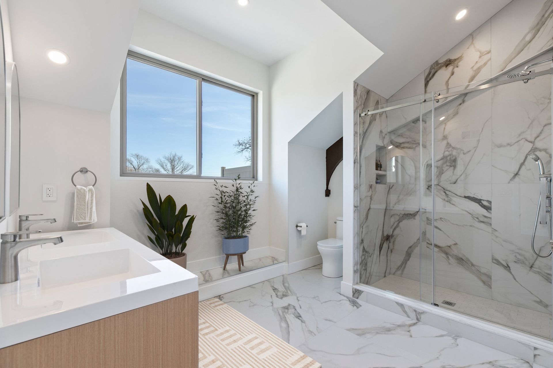 Penthouse layout bathroom with large format tile and double vanity and natural light