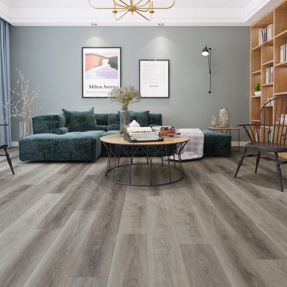 Living room with gray wood-look flooring, teal sofa, round coffee table, and built-in bookshelf.