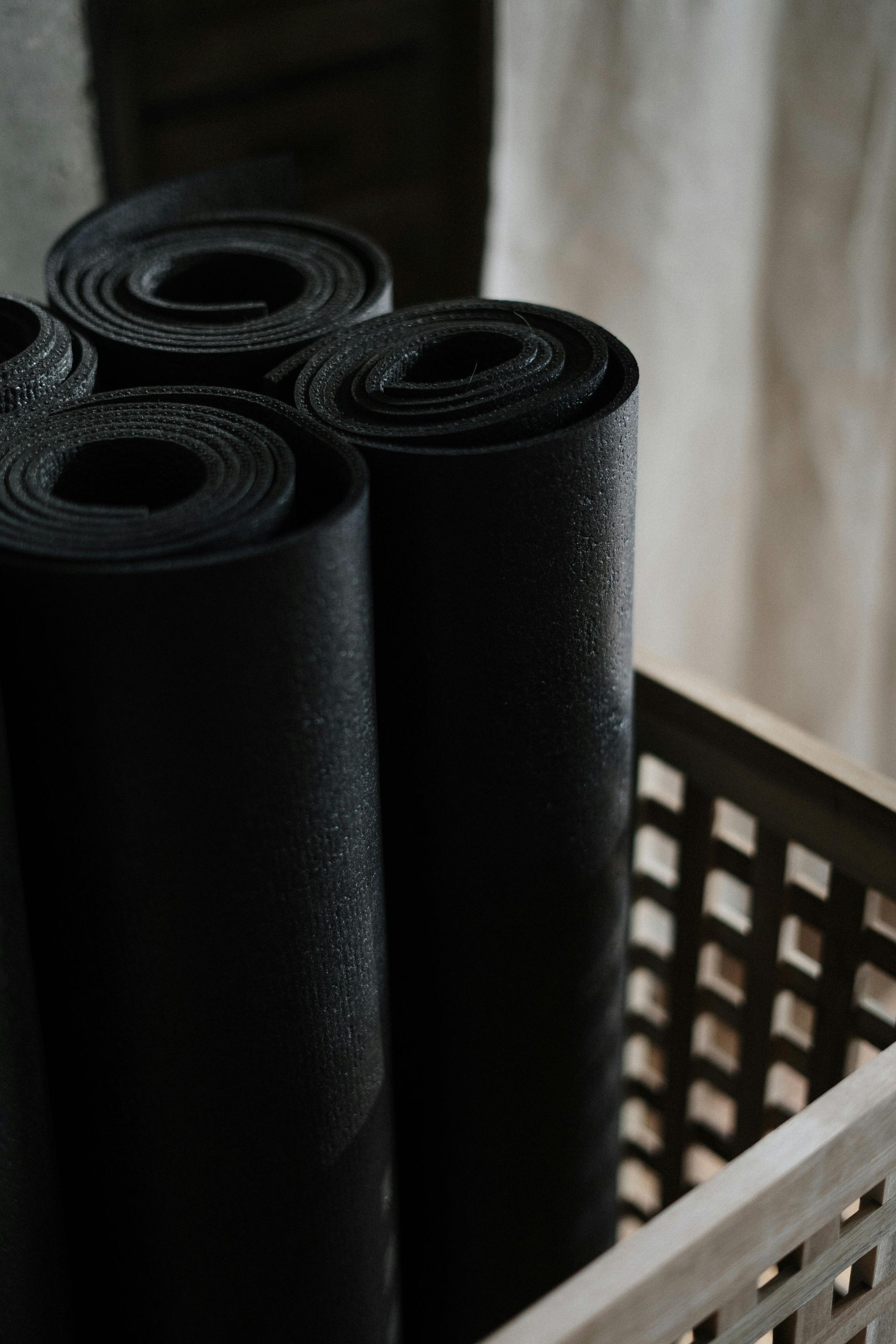 A person lying on a Pilates reformer, holding their legs straight up with straps wrapped around their feet.