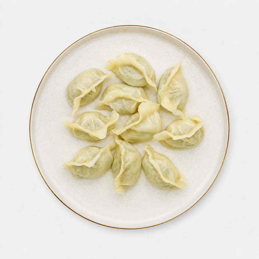Plate of pale dumplings arranged in a circle on a white background