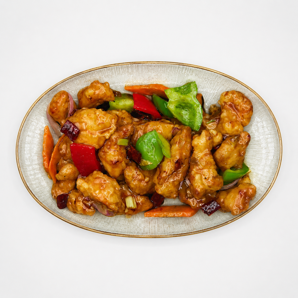 Oval plate of glazed chicken stir-fry with red and green bell peppers and carrots