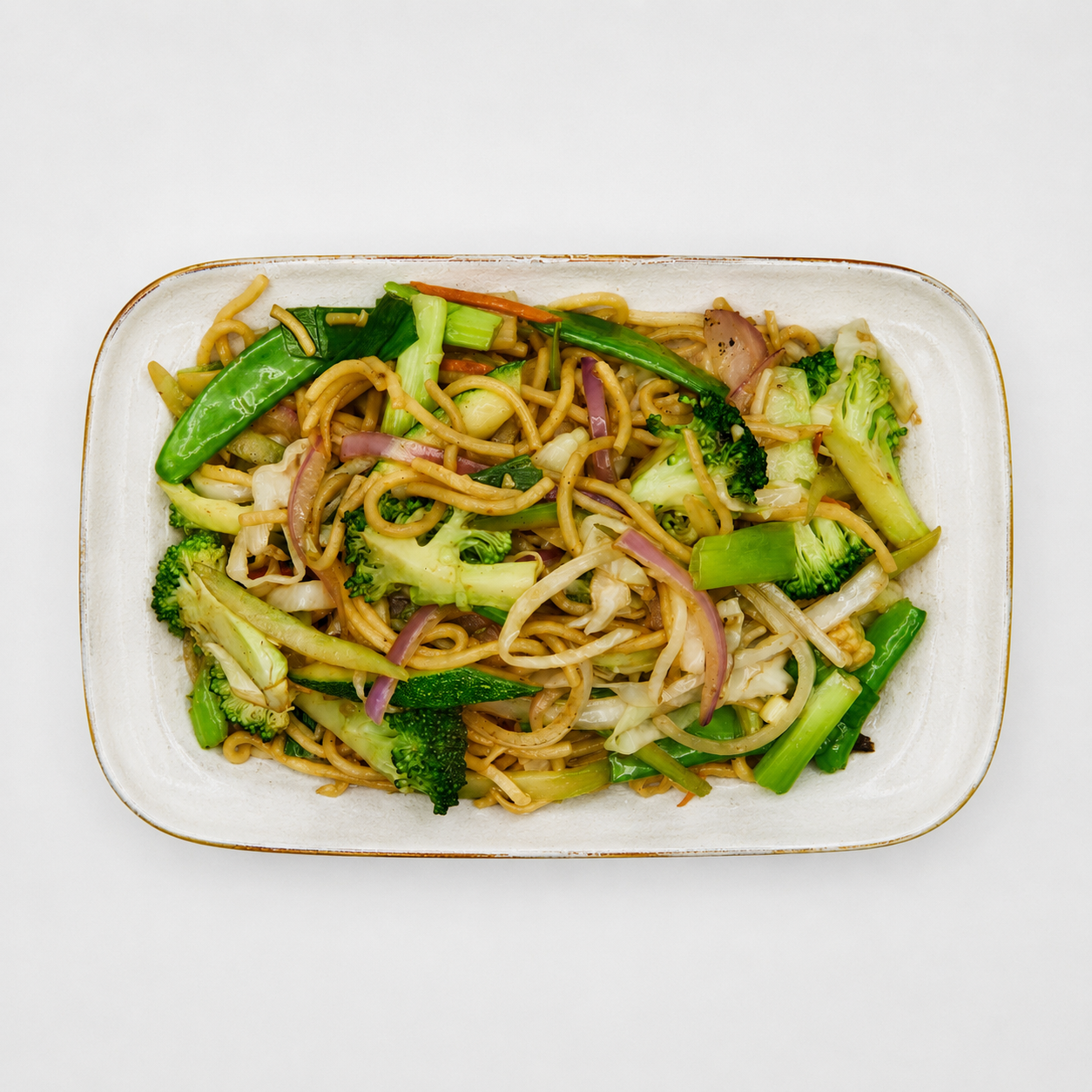 Stir-fried noodles with broccoli and onions on a white rectangular plate