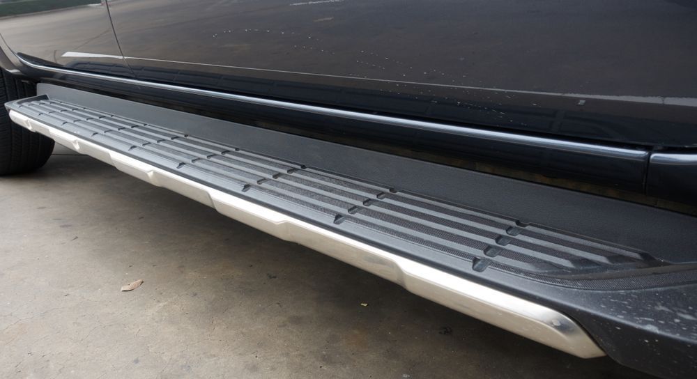 A Black Car With Side Steps is Parked on the Side of the Road — Outlaw Mechanical & Performance In Inverell, NSW