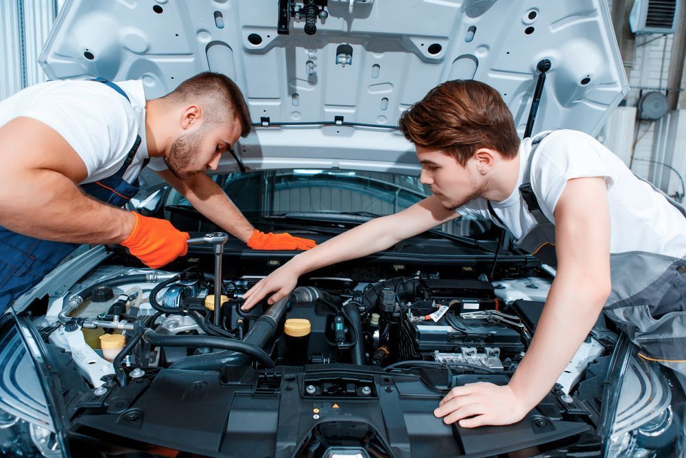 Two Mechanics Are Working on a Car Engine in a Garage — Outlaw Mechanical & Performance In Inverell, NSW
