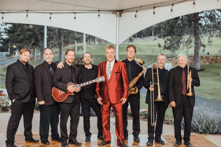 A group of men are standing next to each other under a tent.
