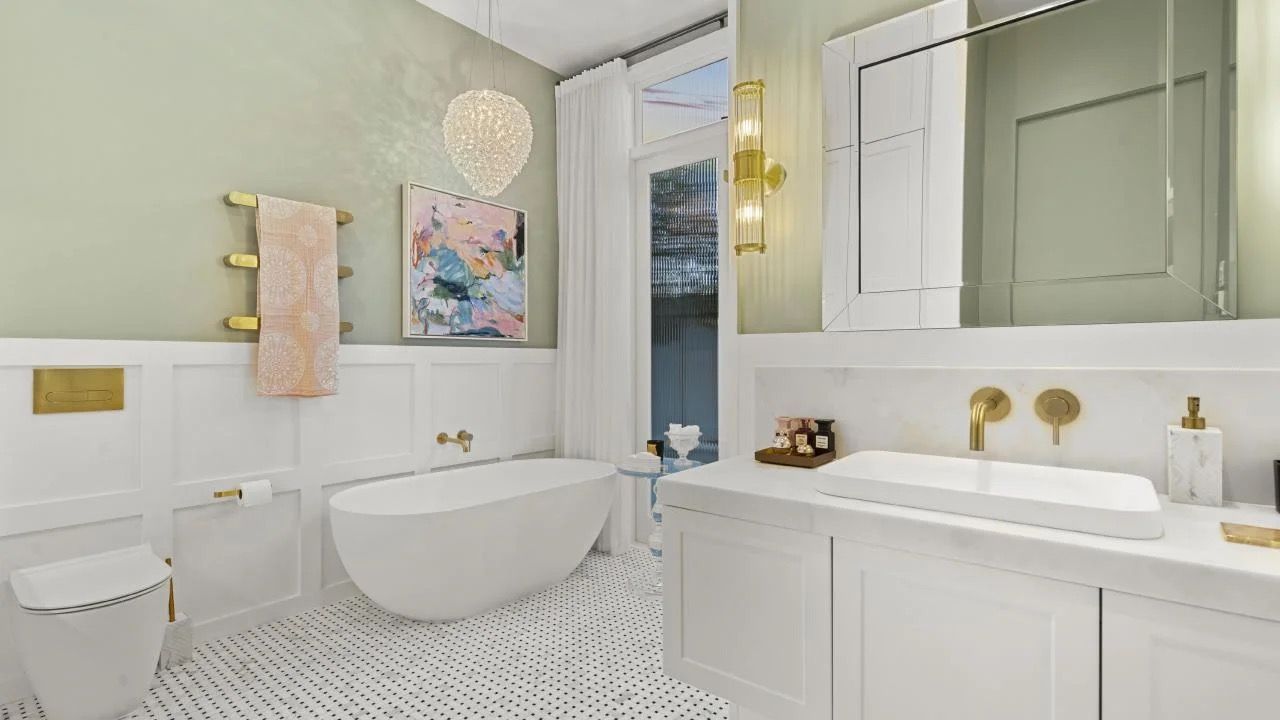 Bright modern bathroom with white tub, vanity, gold fixtures, patterned floor, and pastel wall art