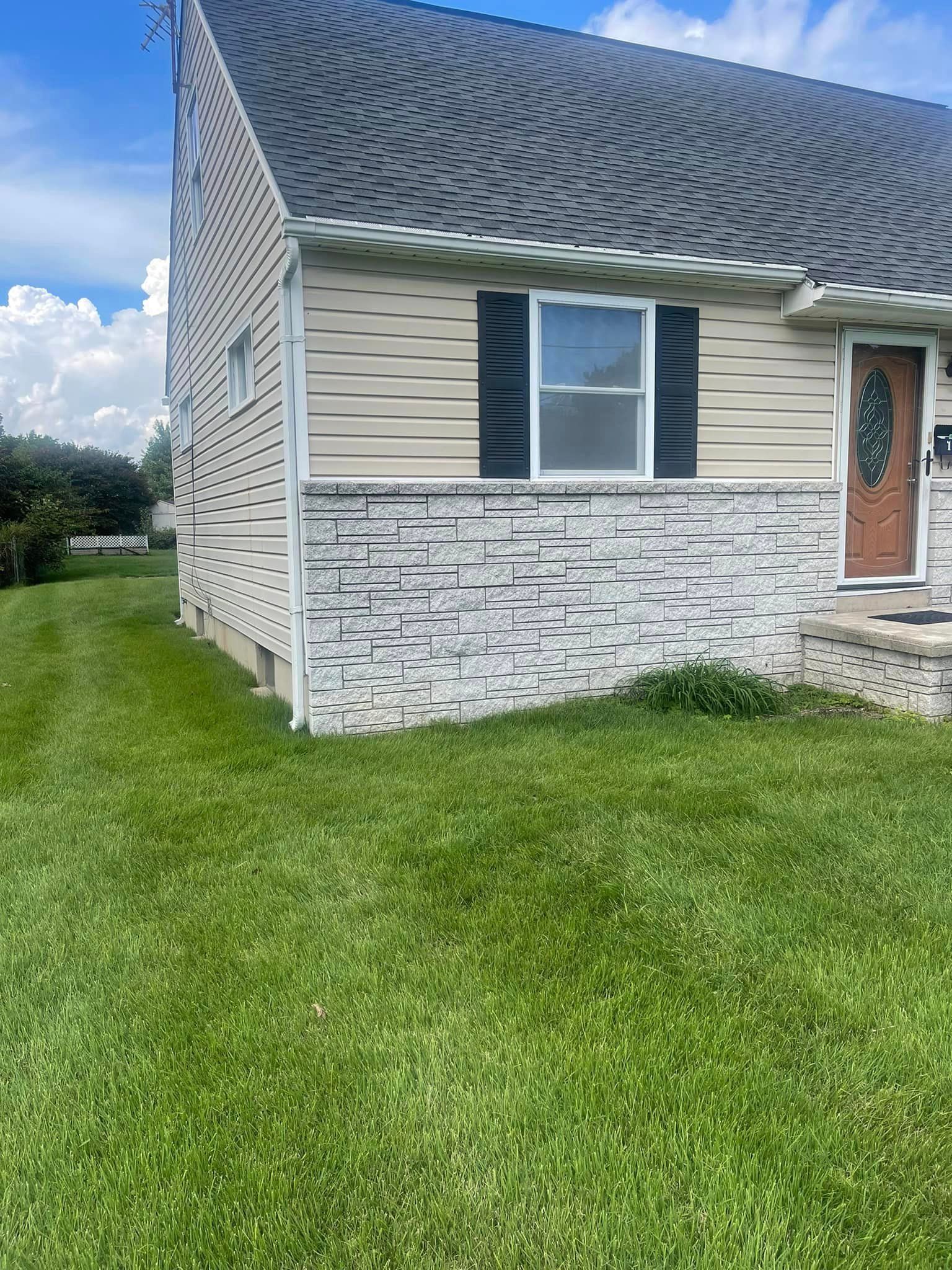 A house with a lush green lawn in front of it.