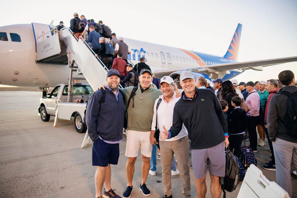 A group of people are standing in front of an airplane.