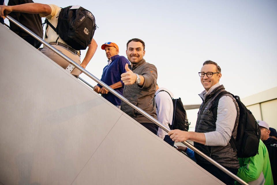 Closeup of golfers on stairway boarding flight to Las Vegas golf tournament.