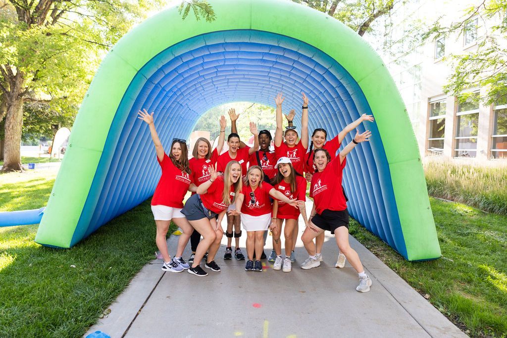 CDF Staff in fun poses under inflatable arch at Run for the Ring Kids Fun Run.