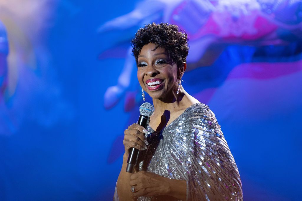 A woman is singing into a microphone on a stage.