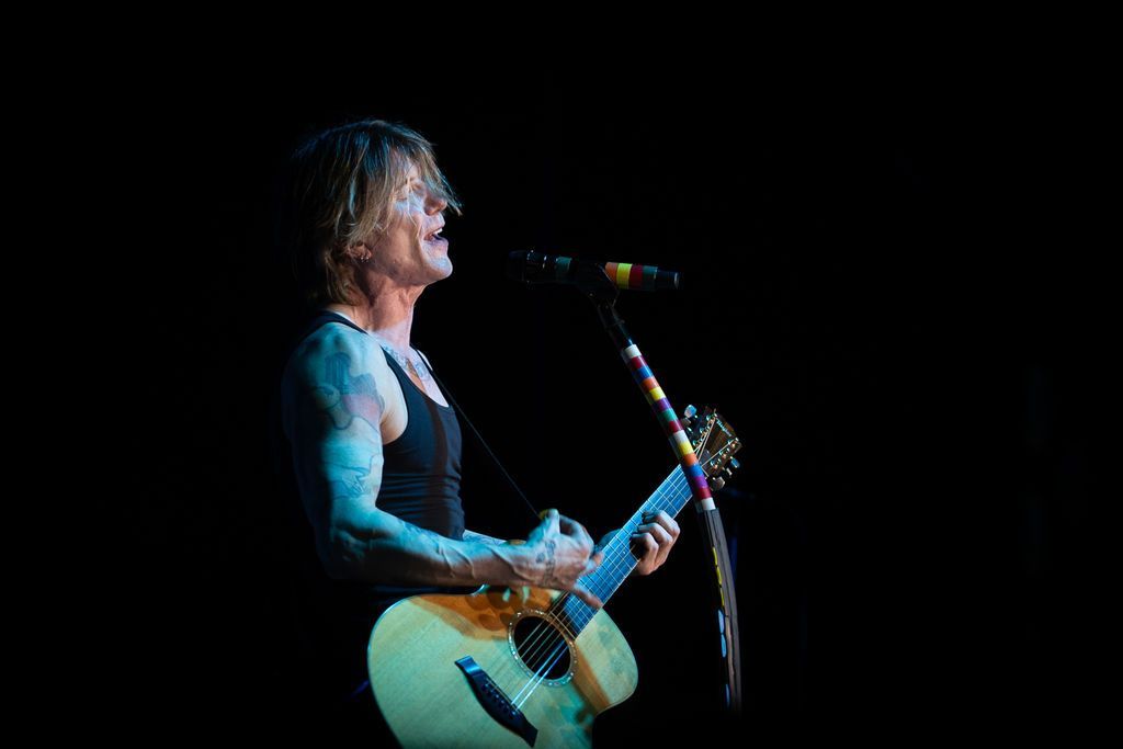 goo goo dolls lead singer johnny rzeznik on stage singing with acoustic guitar
