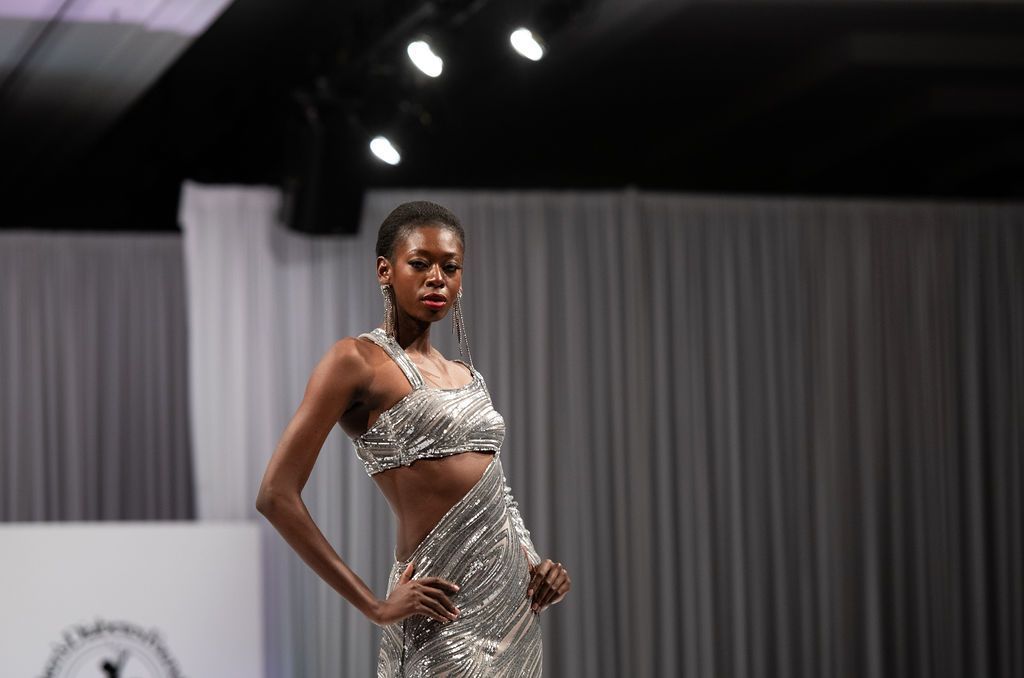 Closeup of model on runway in Marc Bouwer silver strappy evening gown.