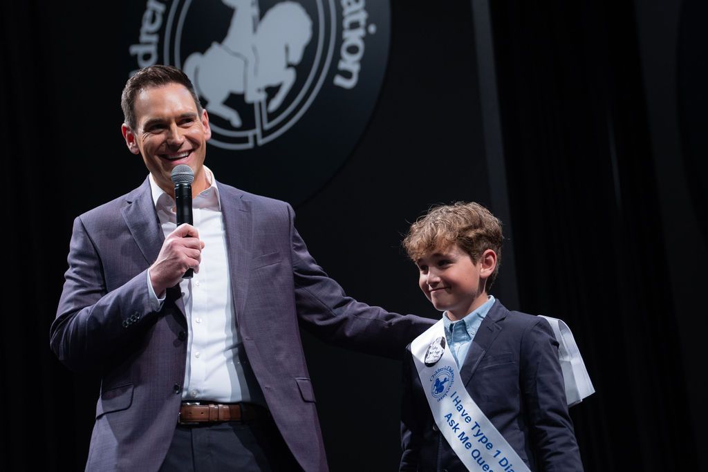 Emcee and news anchor Michael Spencer on stage with T1D advocate boy