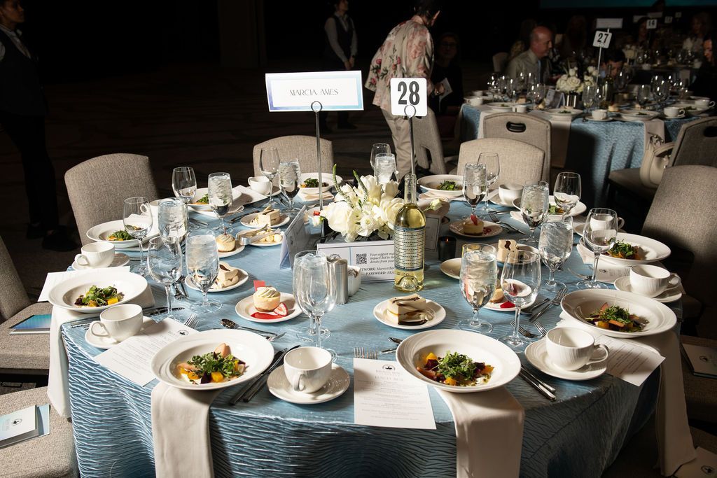 table set with salads and wine with light blue table cloth