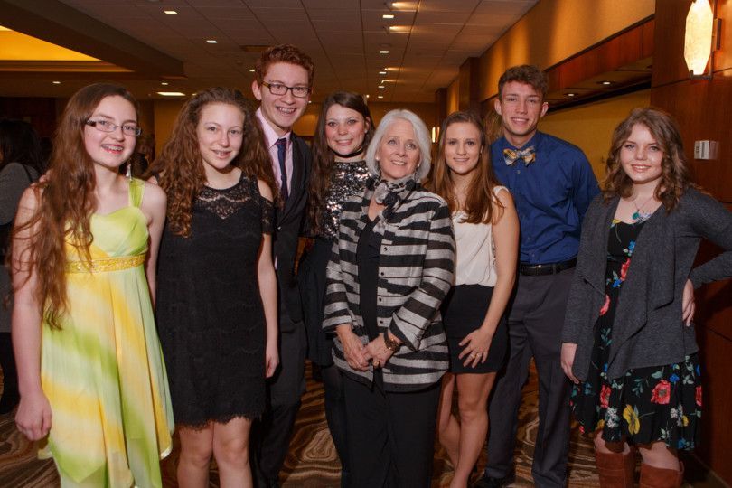 A group of people are posing for a picture in a hallway.