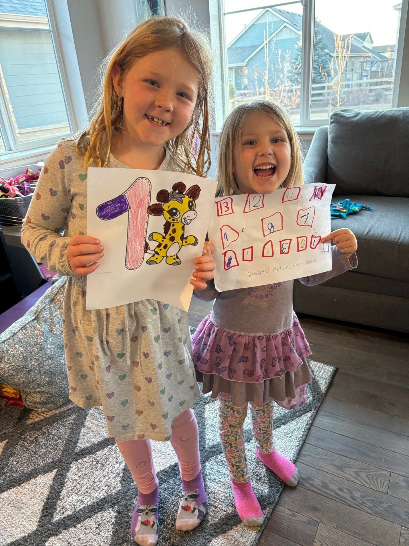 Young sisters Anna and Ellie Belz holding signs up and smiling together