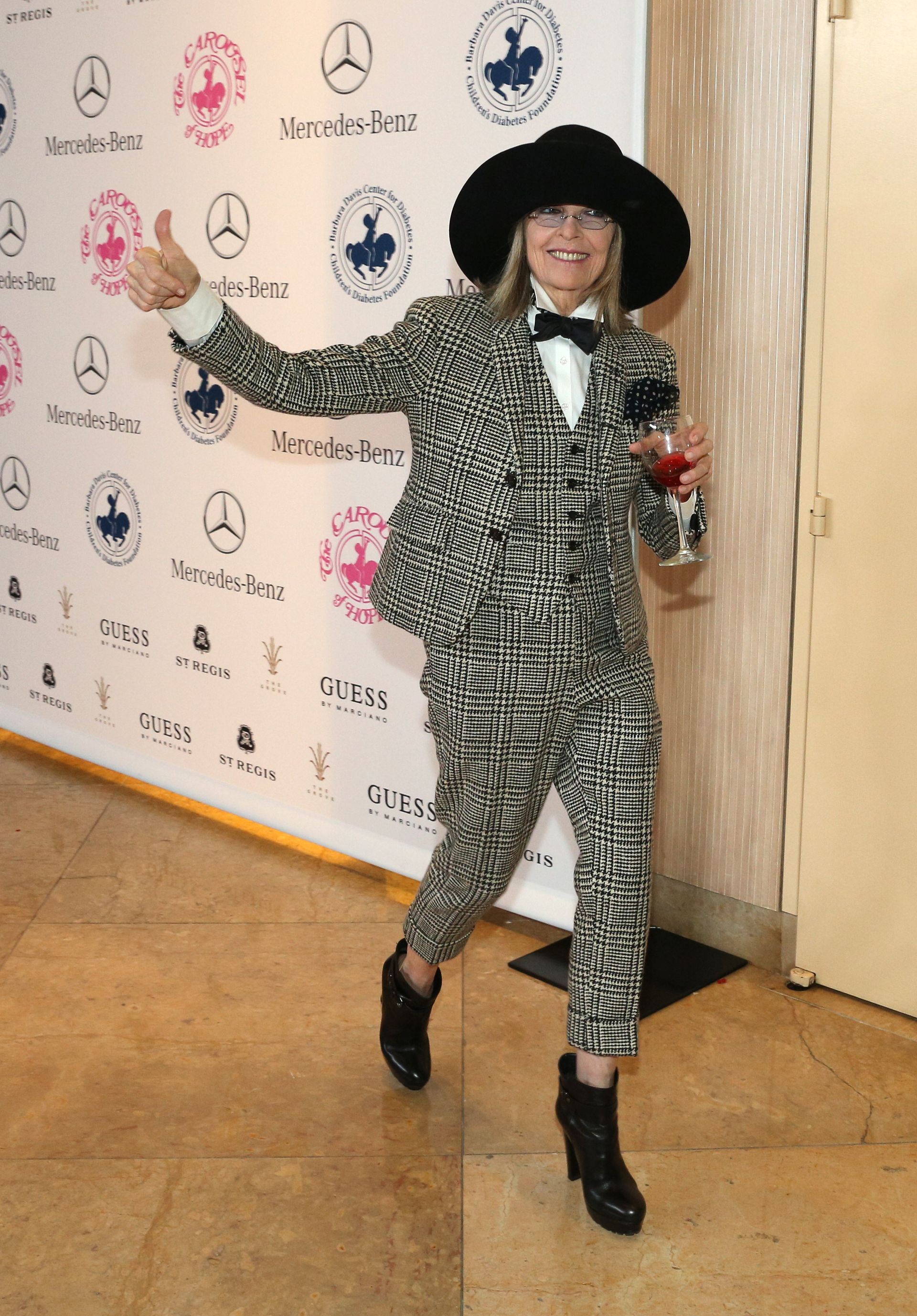 Diane Keaton at the Carousel of Hope Ball in a suit with a glass of wine