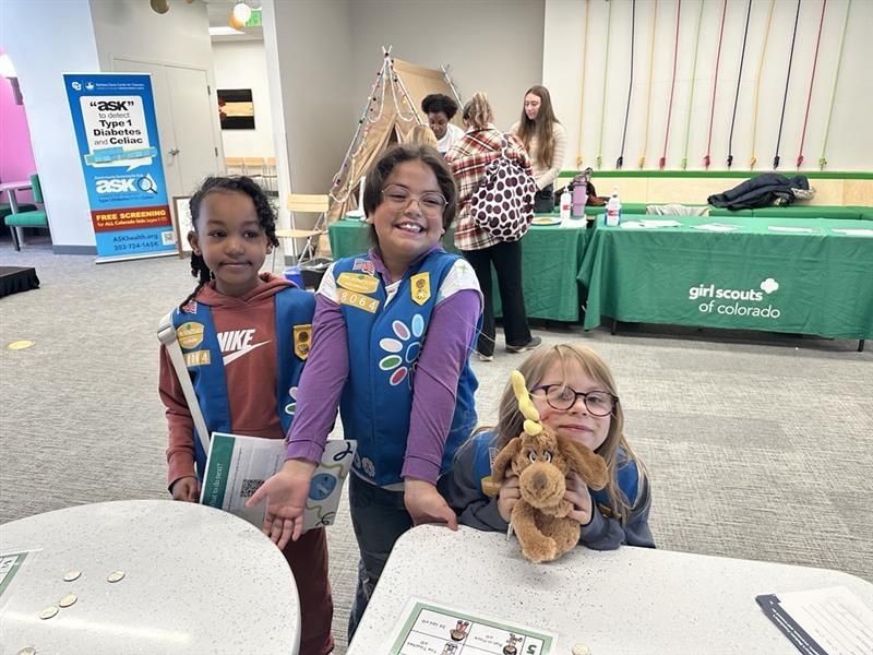 three young girls in their girl scout vests learning about diabetes