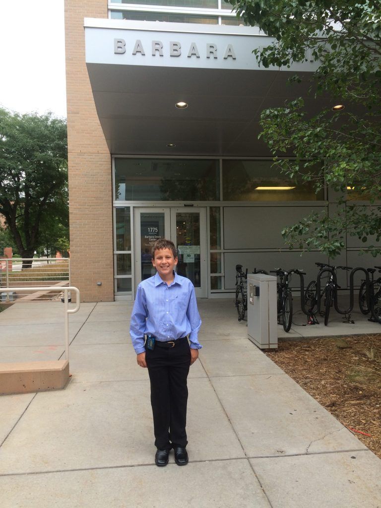 A boy stands in front of the barbara building