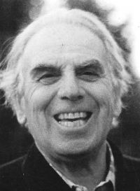 A black and white photo of an older man smiling.