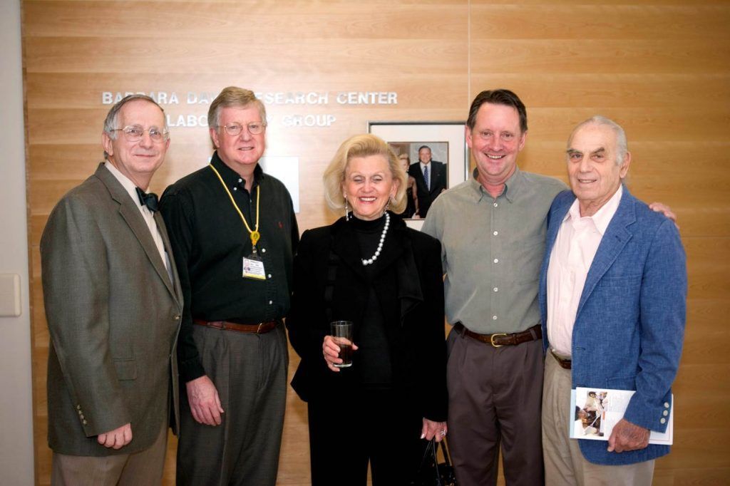 A group of people posing for a picture in front of a sign that says research center