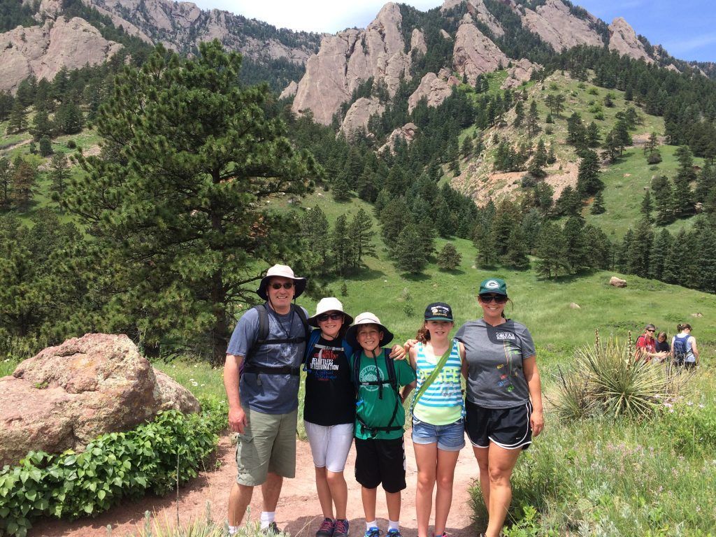 A family is posing for a picture in front of a mountain.