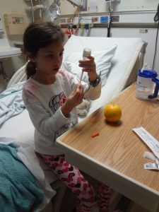 young type 1 patient practicing insulin with needle on an orange