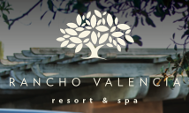 Rancho Valencia resort and spa logo with graphic of tree and background rooftop