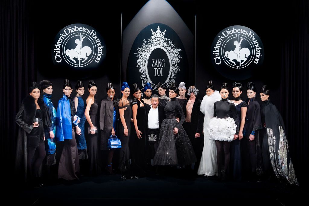 Zang Toi standing with all models on runway at conclusion of fashion show