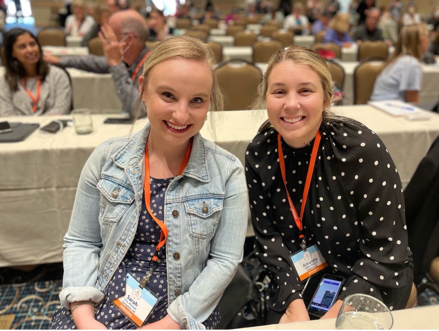 Two female ATDC attendees sitting together and smiling at the conference.