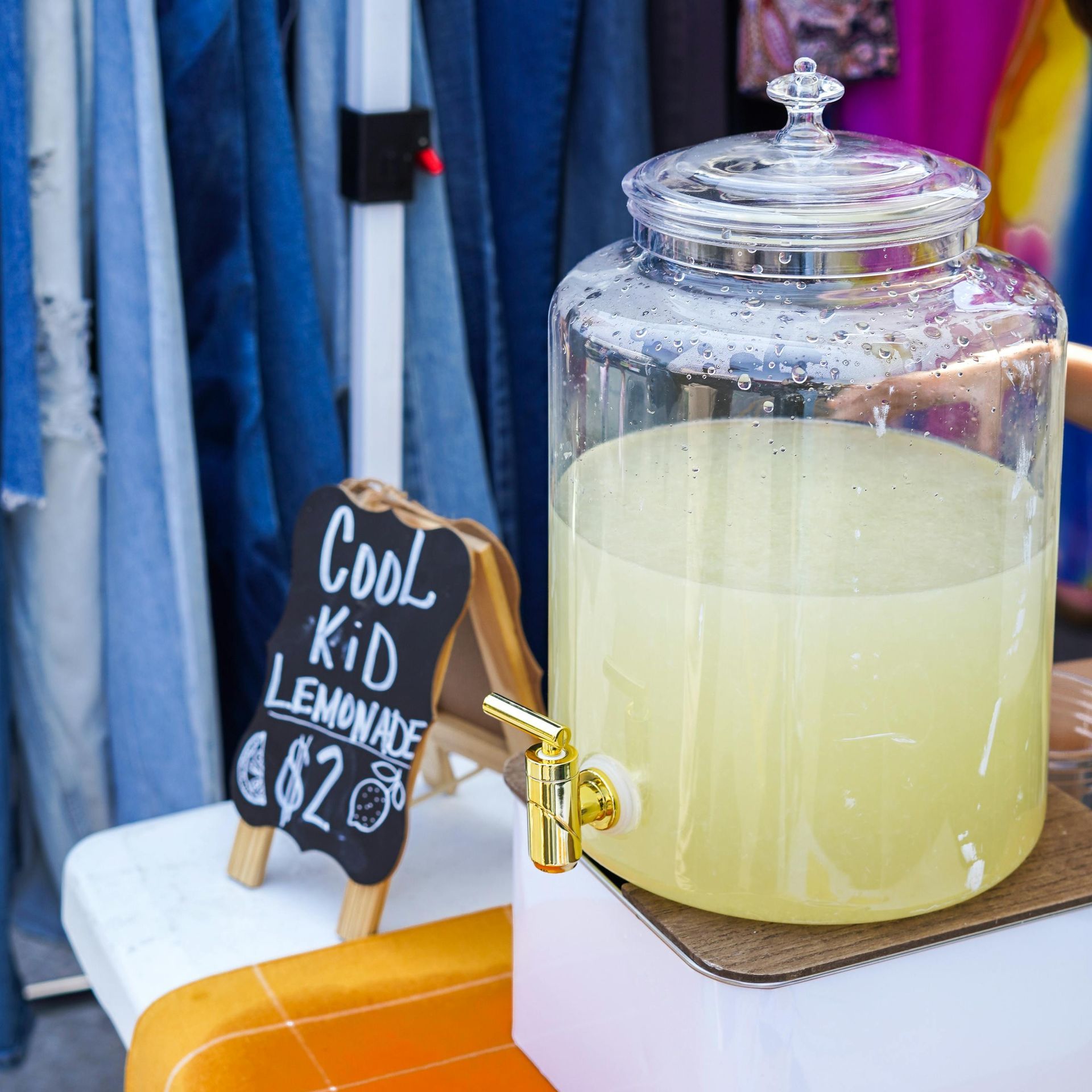 Jug of lemonade at stand with sign reading 