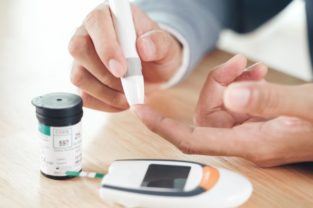 Man using lancet of finer for checking blood sugar level by glucose meter.