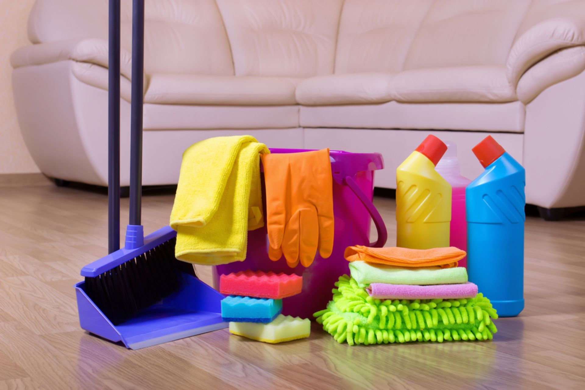 A living room with cleaning supplies and a couch in the background