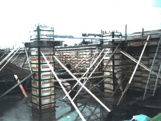 Chantier de construction avec coffrage en béton et échafaudages.