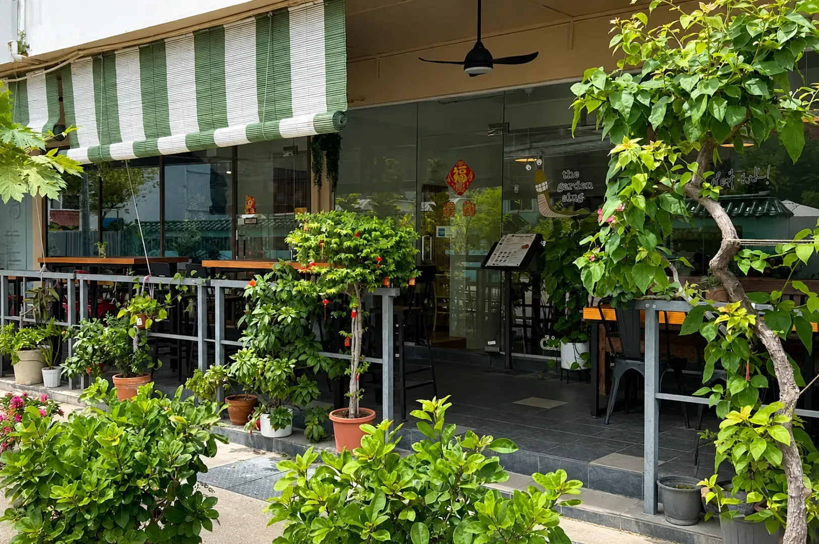 Street-front plant shop with potted greenery and a striped awning