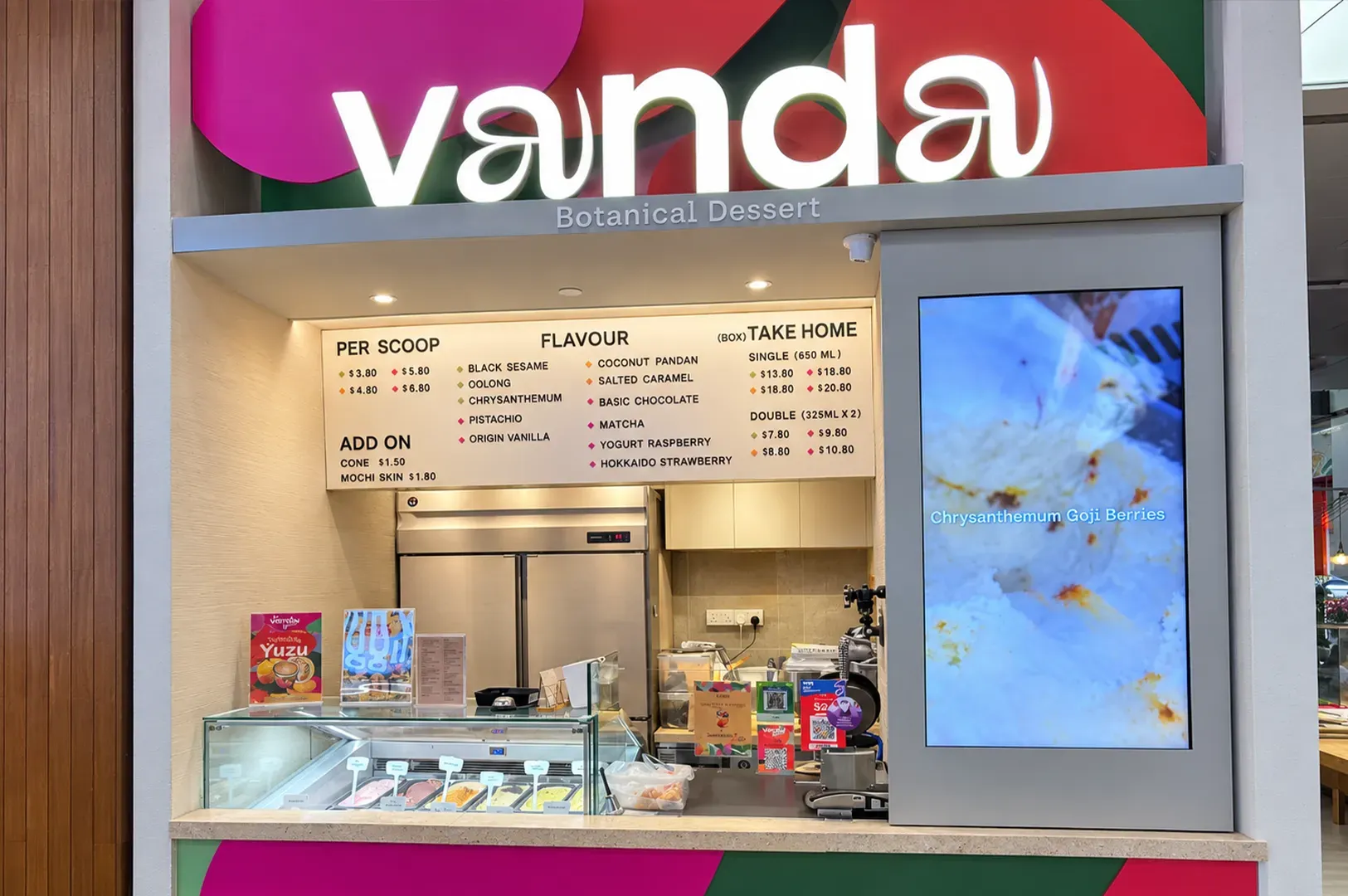 Vanda dessert kiosk with illuminated menu, display case, and pastel treats inside a mall