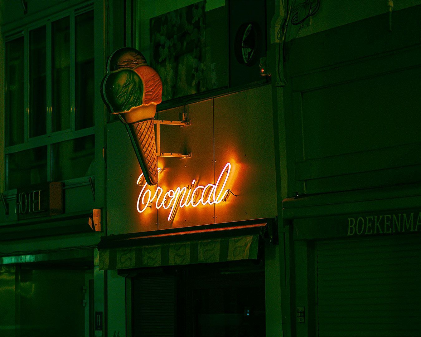 A bright “ice cream” sign glowing outside a dessert shop, inviting customers in for sweet treats dur