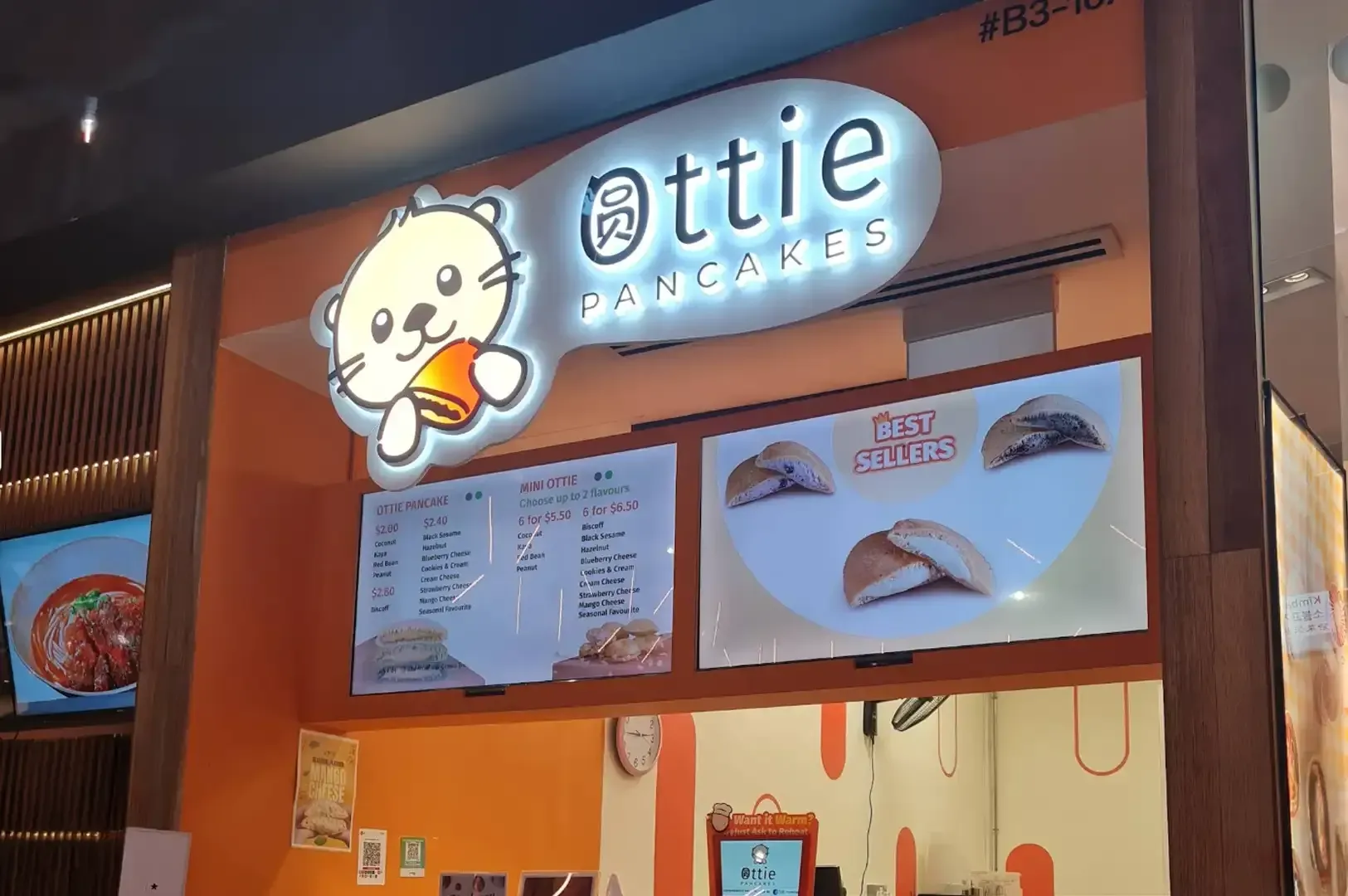 Cute orange-and-white shopfront sign for “attie donuts” with menu boards and donut illustrations