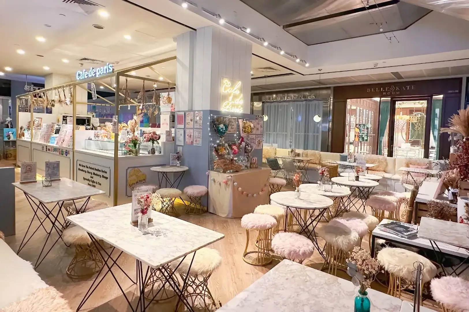 Bright cafe interior with marble tables, woven chairs, and warm lighting in a stylish open dining space