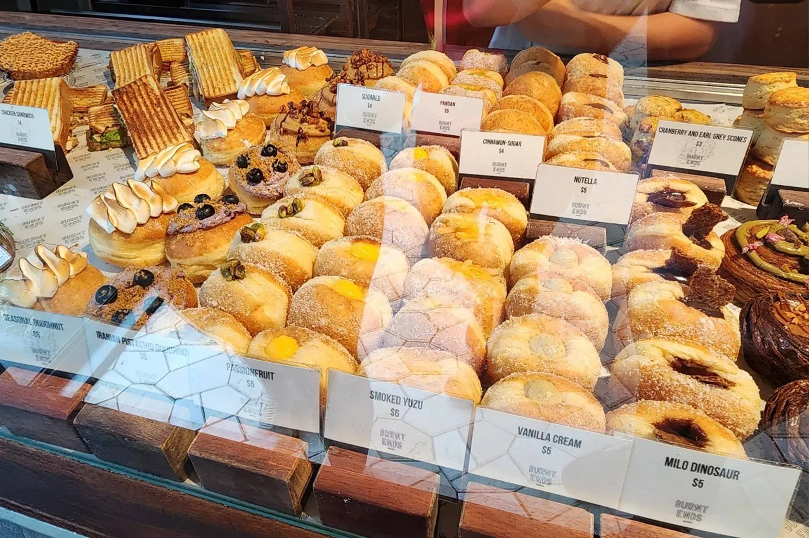 Bakery display case filled with assorted pastries, cakes, and labeled desserts
