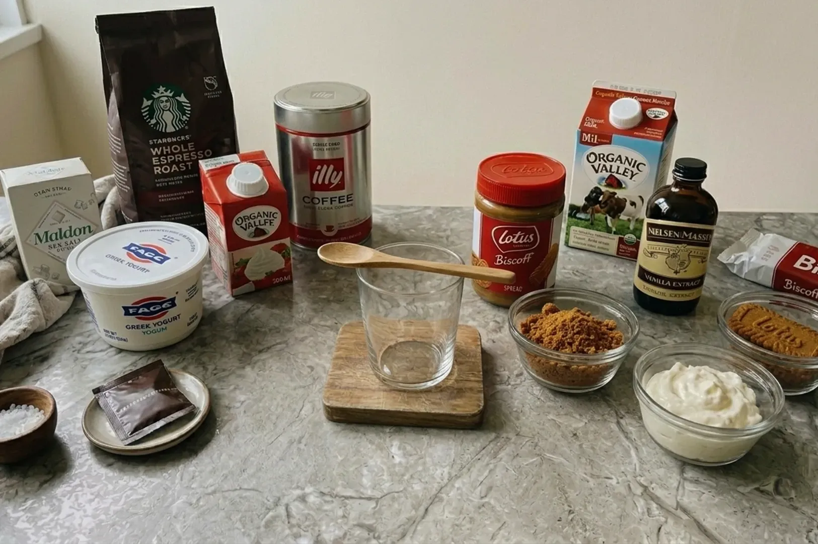 Assorted baking ingredients and tools arranged on a countertop, including flour, sugar, eggs, vanilla, and bowls