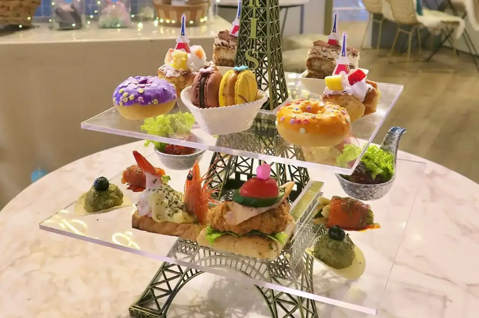 Elegant dessert tower with colorful pastries on glass shelves at a banquet table