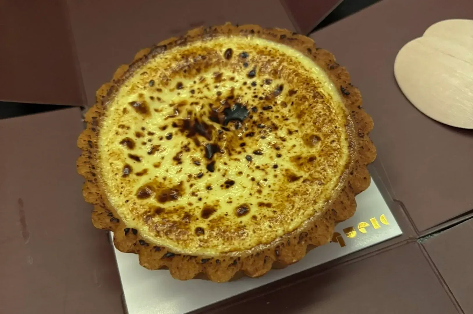 A round baked tart with a golden-brown top on a tray