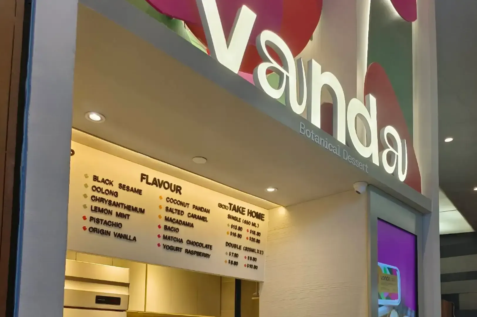VanHaa storefront with illuminated menu board and colorful signage above the counter