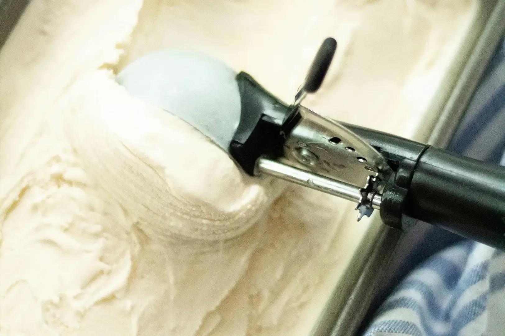 Wood-burning tool tip carving a wooden surface, with smoke rising from the heated nib