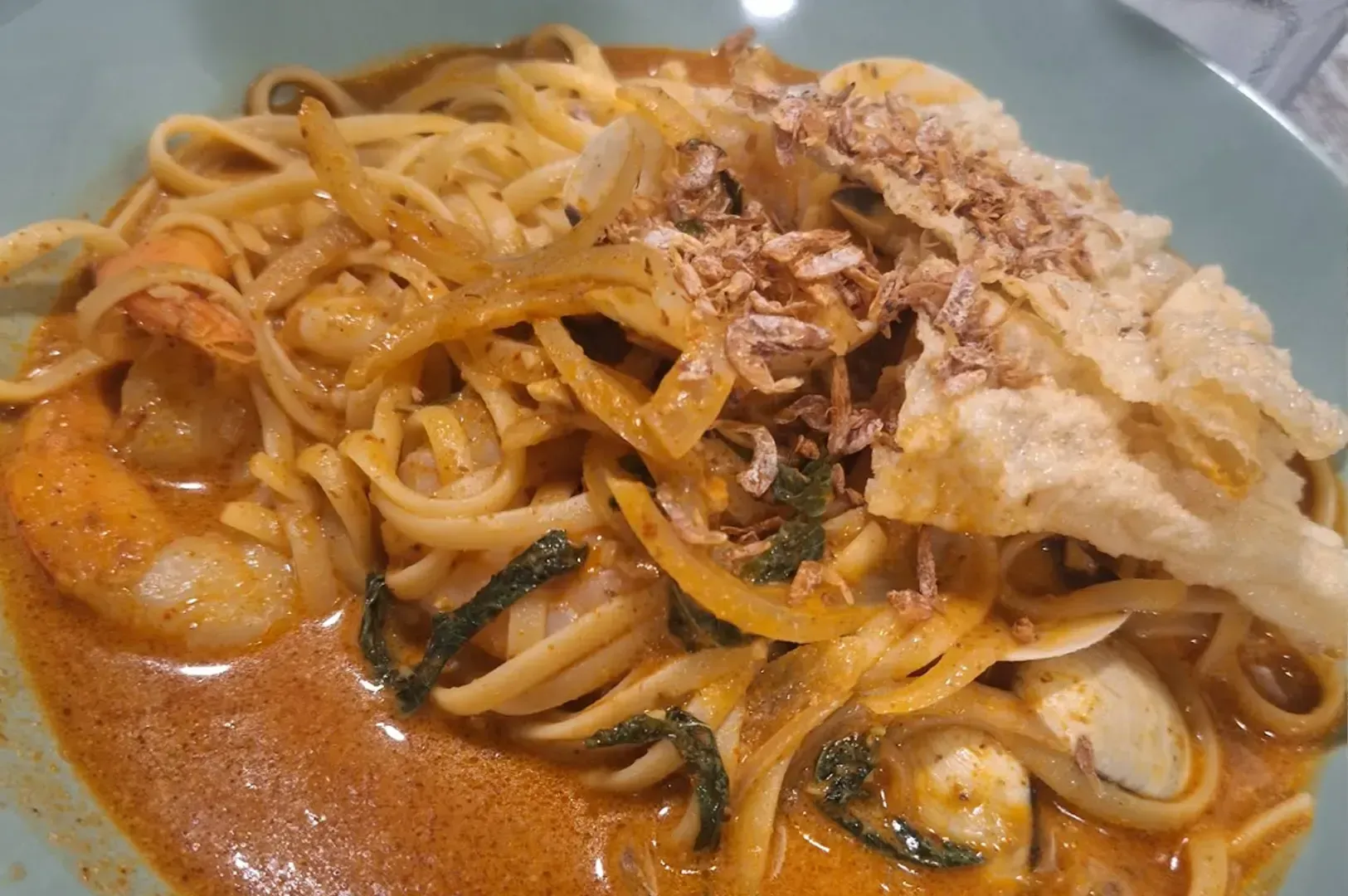 Spaghetti in red sauce with shrimp, mushrooms, and grated cheese on a plate