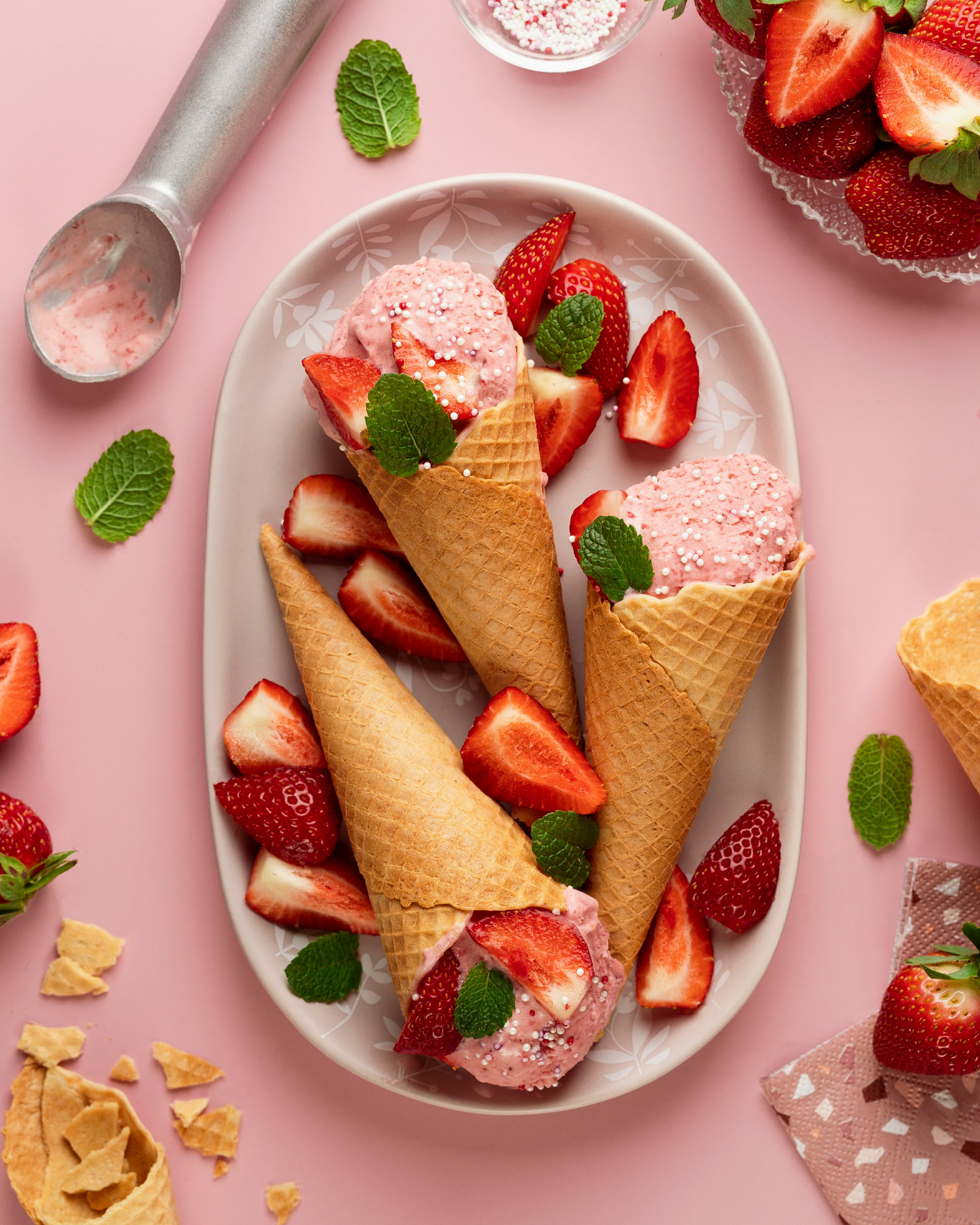 A scoop of strawberry ice cream with a soft pink colour and visible fruit texture, served in a bowl and appearing creamy and refreshing.